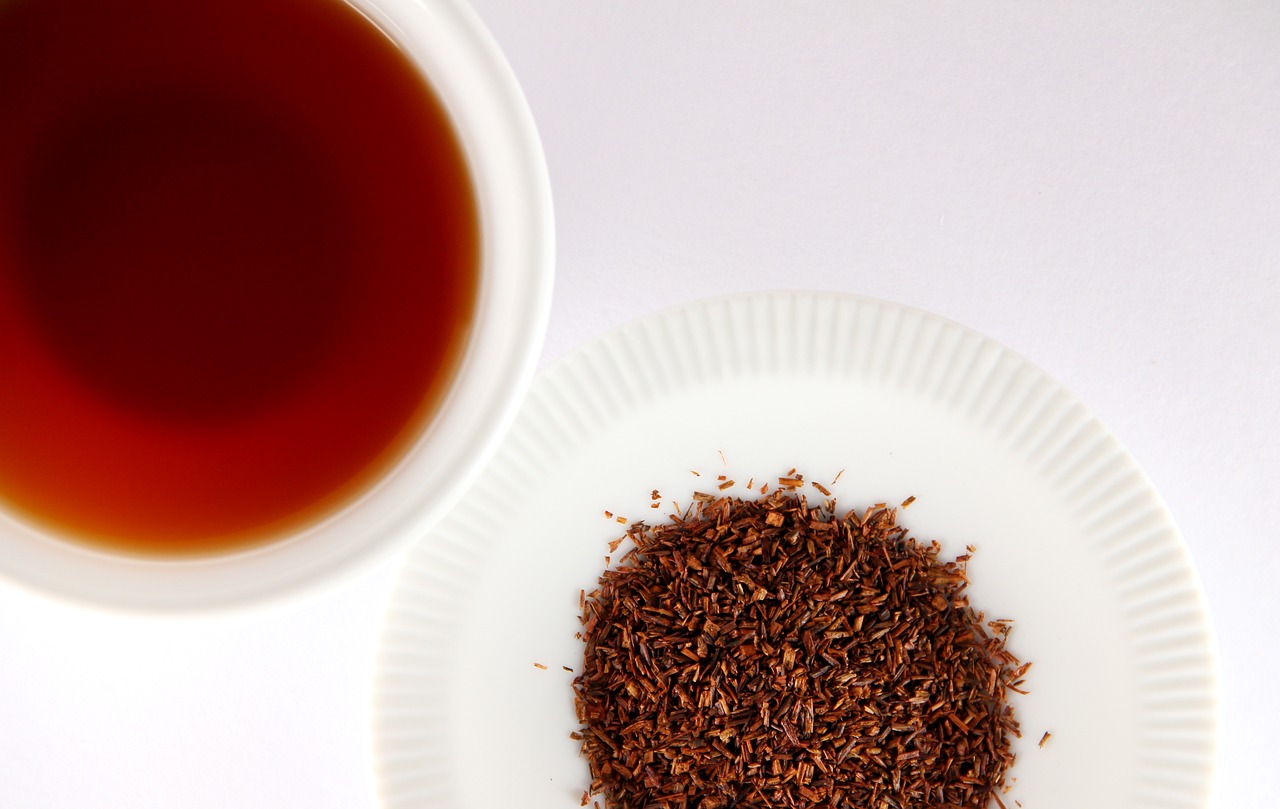 ceai rooibos uscat pe farfuriuta si infuzie de ceai rooibos intr-o cana